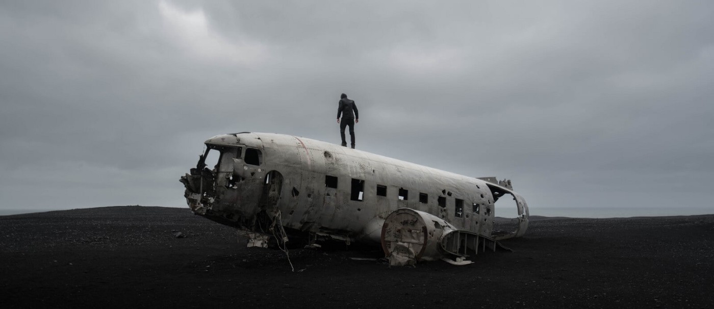 Man standing on crashed / abandoned plane Photo by Joshua Sortino on Unsplash