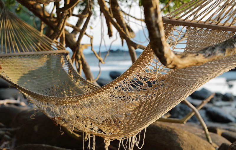 Hammock up close on a beach “Photo by Maksim Shutov on Unsplash”